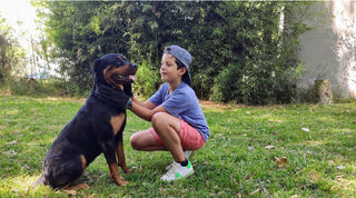 A boy with a healthy, happy Rottweiler in a backyard